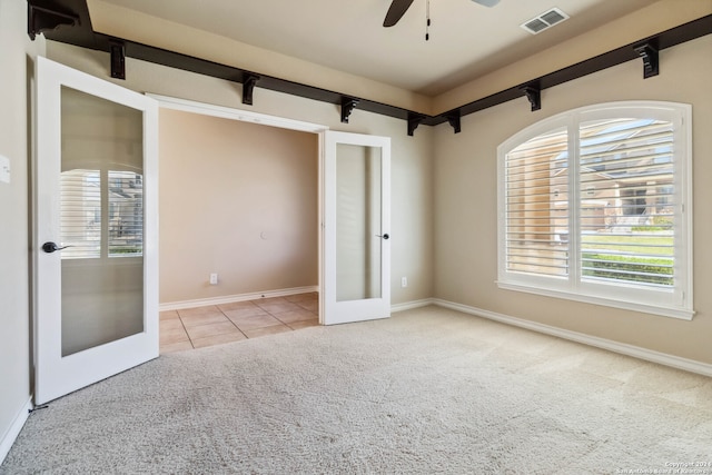 unfurnished bedroom with french doors, light colored carpet, and ceiling fan