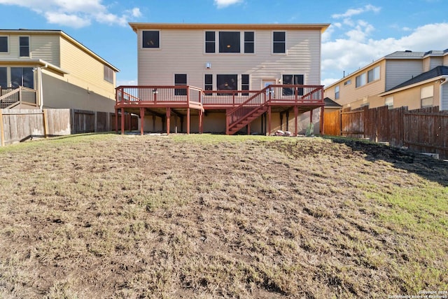 back of property with a lawn and a wooden deck