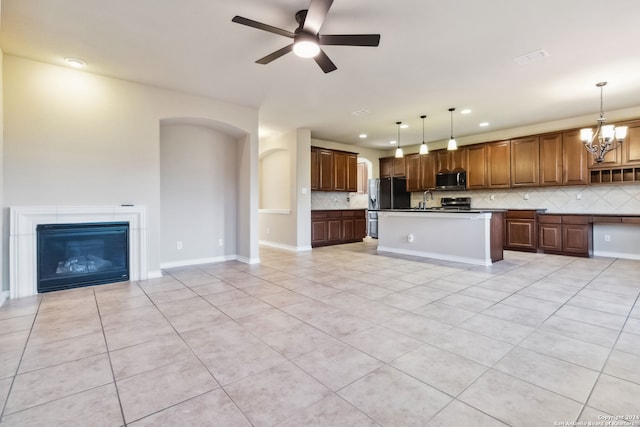 kitchen featuring pendant lighting, backsplash, and an island with sink