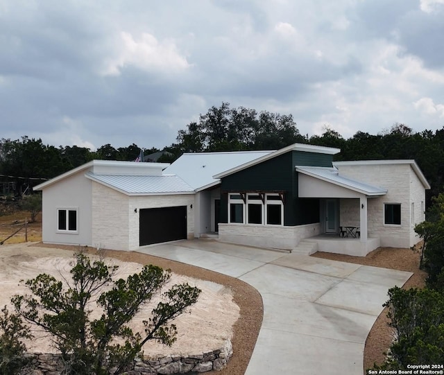 2920 Rocky Ridge Loop, Canyon Lake, TX 78133 - view of front of property featuring driveway, an attached garage, stone siding, and metal roof