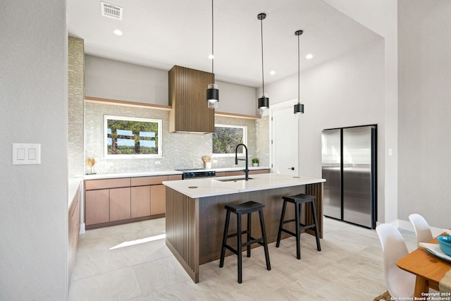 2920 Rocky Ridge Loop, Canyon Lake, TX 78133 - kitchen featuring freestanding refrigerator, backsplash, light countertops, a sink, and a center island with sink