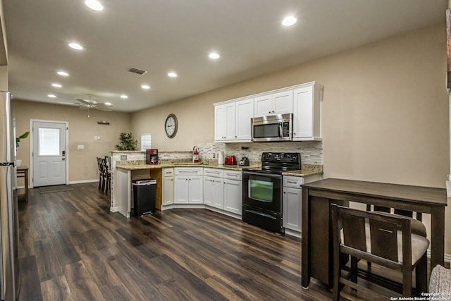 kitchen featuring dark wood-type flooring, black range with electric cooktop, white cabinetry, and ceiling fan