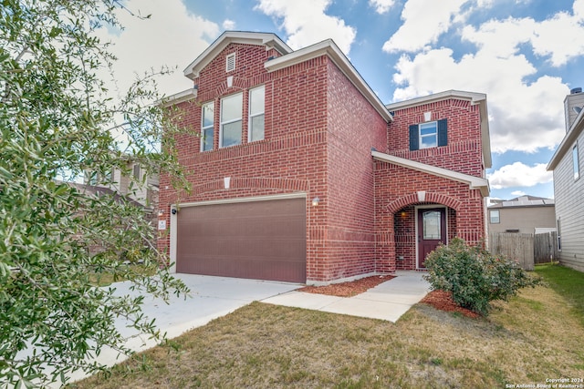 townhome / multi-family property featuring a garage and a front lawn