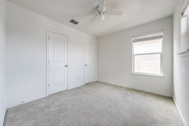 unfurnished bedroom featuring ceiling fan and light colored carpet