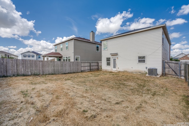 back of house featuring central AC unit, a lawn, and a gazebo