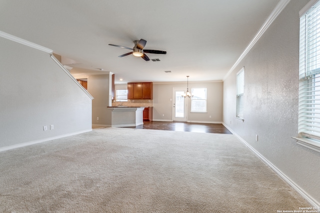 unfurnished living room featuring ceiling fan with notable chandelier, dark carpet, and ornamental molding