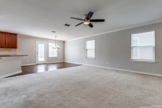 unfurnished living room with a textured ceiling, ceiling fan with notable chandelier, ornamental molding, and dark hardwood / wood-style floors