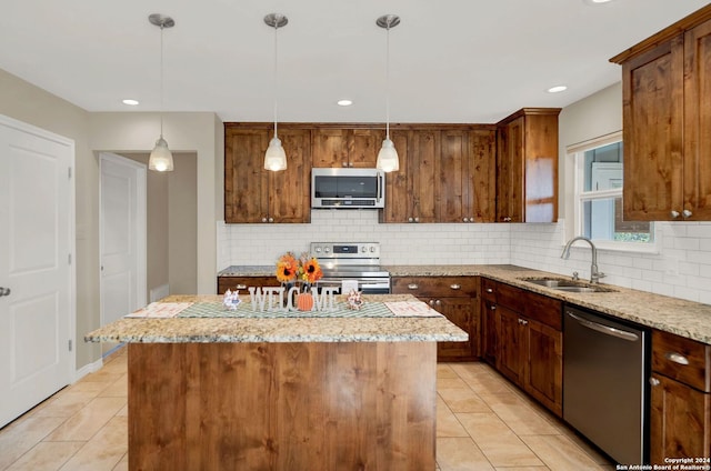 kitchen featuring light stone counters, sink, a kitchen island, and appliances with stainless steel finishes