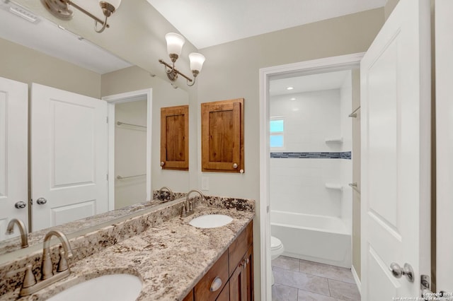 full bathroom featuring tile patterned floors, toilet, an inviting chandelier, tiled shower / bath combo, and vanity