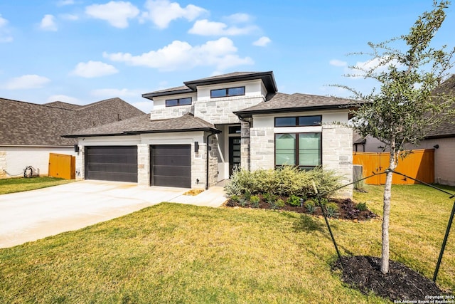 prairie-style home with a garage and a front lawn