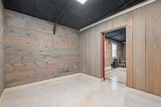 basement featuring wooden walls