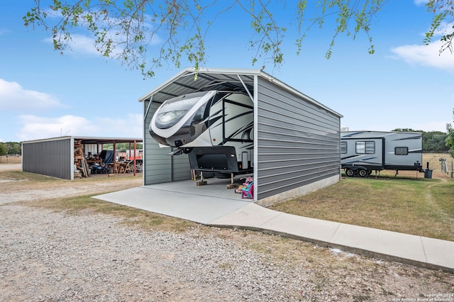 view of outbuilding featuring a carport and a lawn