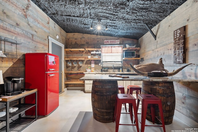 kitchen featuring lofted ceiling and stainless steel refrigerator