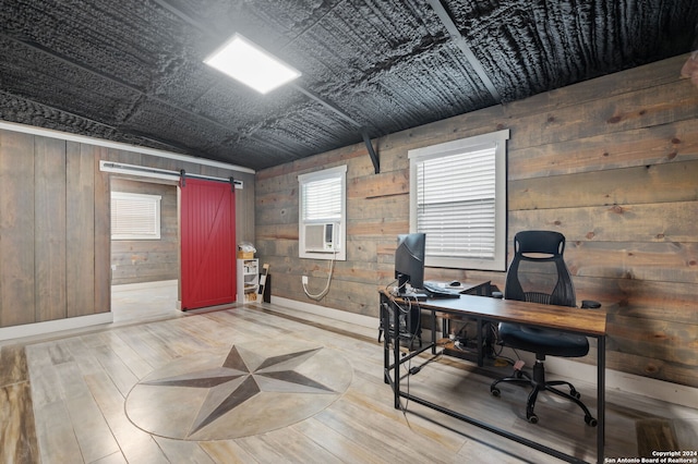 home office featuring cooling unit, a barn door, wooden walls, hardwood / wood-style floors, and vaulted ceiling