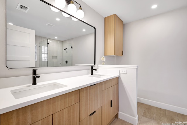 bathroom featuring vanity, an enclosed shower, and hardwood / wood-style flooring