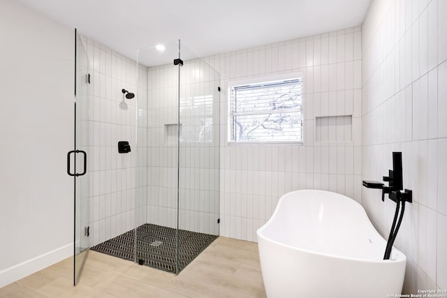 bathroom featuring tile walls, hardwood / wood-style floors, and separate shower and tub