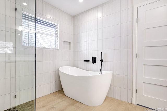 bathroom featuring independent shower and bath, tile walls, and hardwood / wood-style flooring