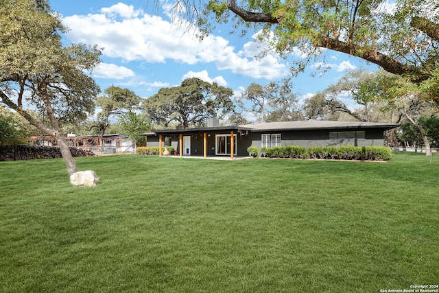 rear view of property featuring a lawn