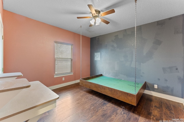 bedroom with dark wood-type flooring and a textured ceiling