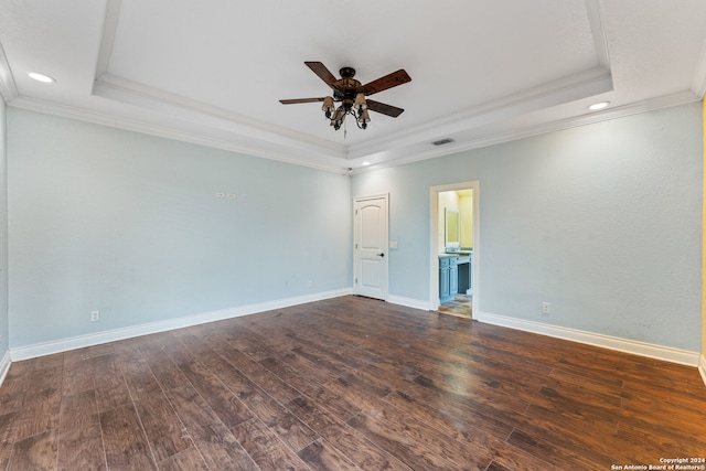 spare room featuring ornamental molding, dark wood-type flooring, and a tray ceiling