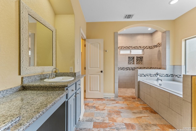 bathroom with vanity, a healthy amount of sunlight, and separate shower and tub