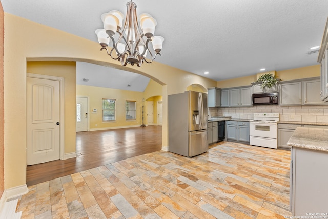 kitchen with light hardwood / wood-style floors, decorative backsplash, black appliances, gray cabinets, and pendant lighting