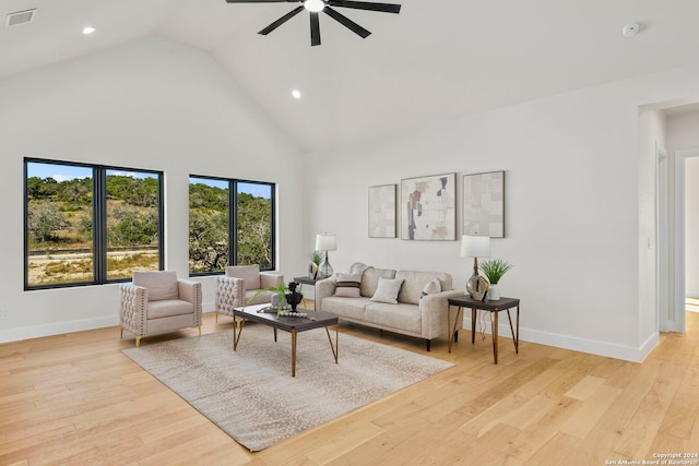 living room with ceiling fan, high vaulted ceiling, and light hardwood / wood-style flooring