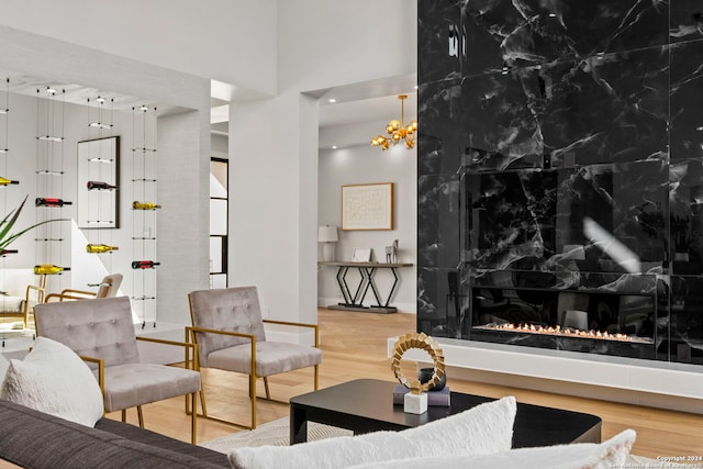 living room with a fireplace, wood-type flooring, and a towering ceiling