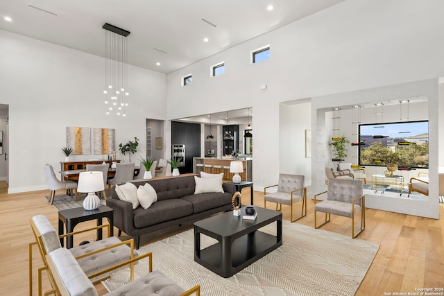 living room featuring a high ceiling and light wood-type flooring