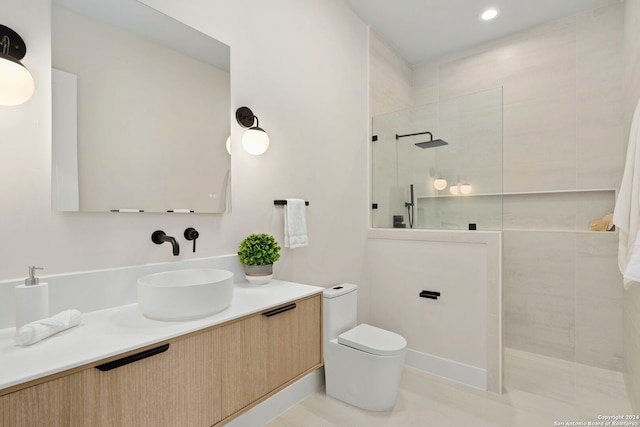 bathroom featuring tile patterned flooring, vanity, toilet, and a tile shower