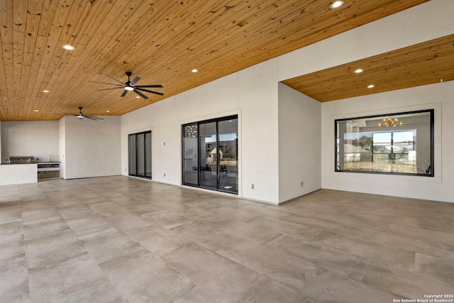 unfurnished living room with wood ceiling and ceiling fan with notable chandelier