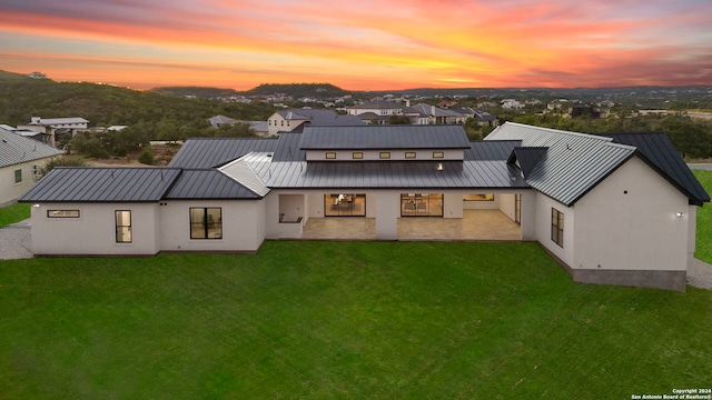 back house at dusk with a yard