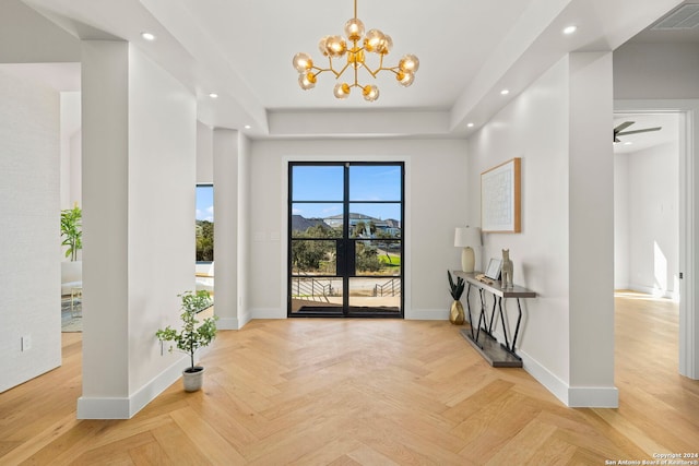 entryway with light parquet floors and ceiling fan with notable chandelier