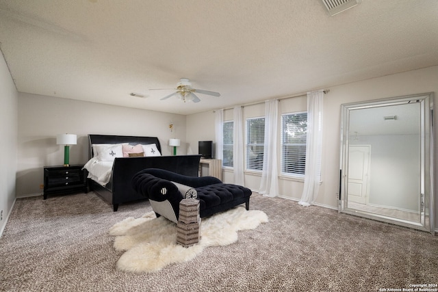 carpeted bedroom with ceiling fan and a textured ceiling