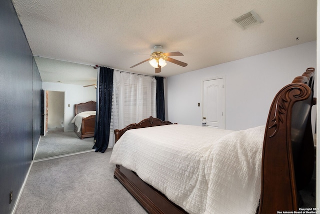 carpeted bedroom featuring ceiling fan and a textured ceiling