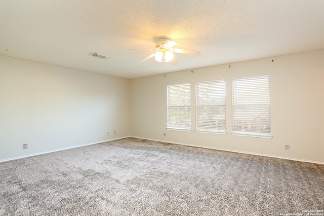 unfurnished room with ceiling fan, carpet, and a textured ceiling