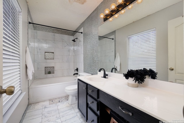 full bathroom with vanity, toilet, a textured ceiling, and tiled shower / bath combo