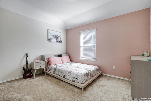 bedroom with light colored carpet and vaulted ceiling