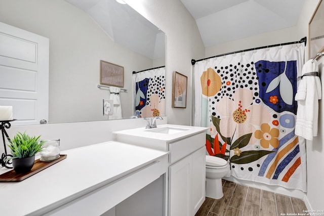 bathroom featuring a shower with curtain, vanity, hardwood / wood-style floors, toilet, and lofted ceiling