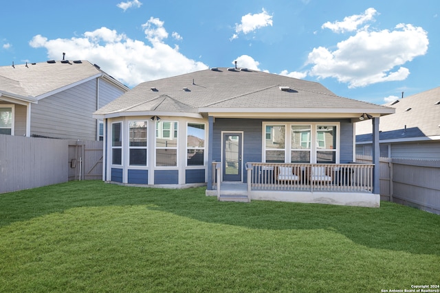 rear view of property featuring a lawn