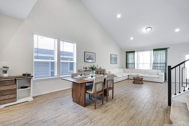 dining area featuring high vaulted ceiling and light hardwood / wood-style floors