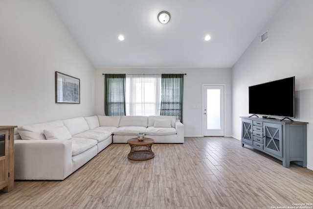 living room with high vaulted ceiling and light wood-type flooring