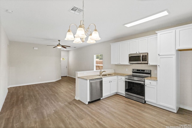 kitchen featuring stainless steel appliances, hanging light fixtures, white cabinetry, and light wood-type flooring