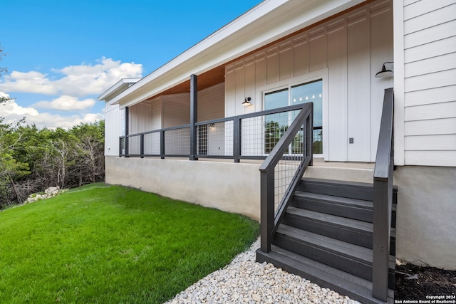 property entrance featuring a lawn