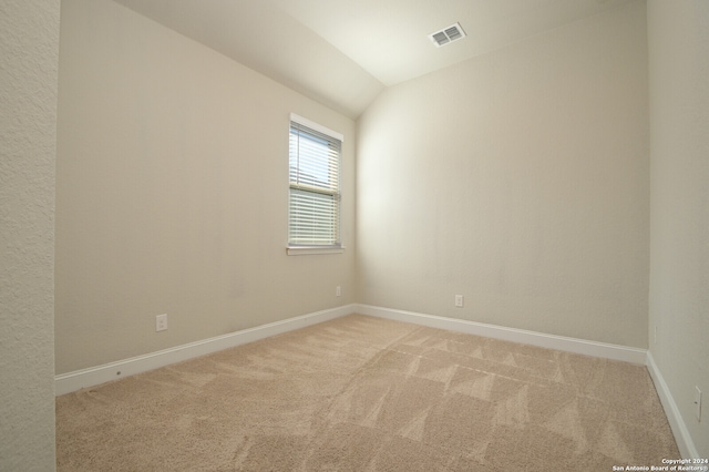 unfurnished room with carpet flooring and vaulted ceiling