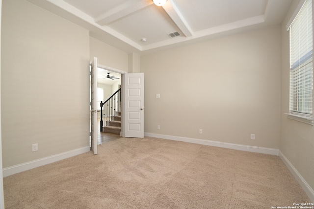 unfurnished bedroom featuring light carpet, multiple windows, and ceiling fan