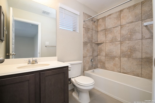 full bathroom featuring toilet, vanity, tiled shower / bath, and tile patterned flooring