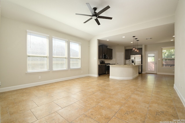 unfurnished living room with ceiling fan with notable chandelier