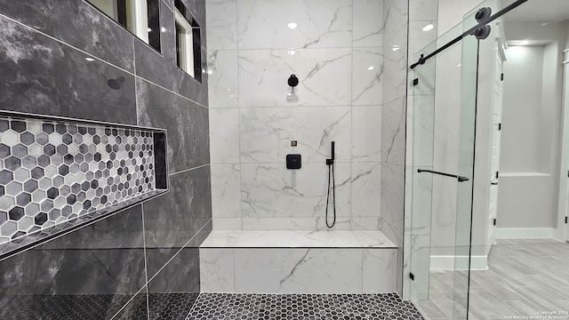 bathroom with a shower with door