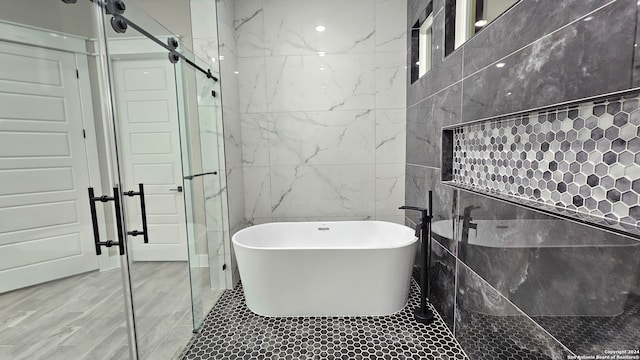 bathroom with tile walls and shower with separate bathtub